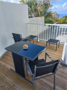 Villa Couleurs du Sud Sauvage في سانت-جوزيف: طاولة زرقاء وكراسي على السطح