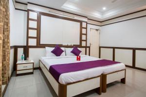 a bedroom with a large bed with purple pillows at Hotel Surya Residency in Ameerpet