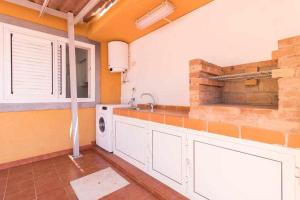 a kitchen with a sink and a washing machine at Villa Mar Deluxe in Castillo del Romeral