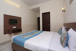 a bedroom with a large bed with a tv on the wall at Hotel Maan's Heritage in Jaipur
