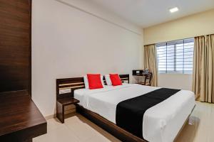 a bedroom with a large bed with red pillows at Collection O World Class Hotel Crescent Near Phoenix Marketcity in Bangalore