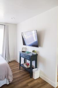 a bedroom with a table with a tv on a wall at Happy Trails BnB in Tropic