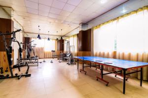 un gimnasio con mesa de ping pong y equipo de ejercicios en Collection O Signature Manaali, en Baragrān