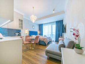 a kitchen and a living room with a couch and a table at Flatbook - City Center Apartments Granaria II in Gdańsk