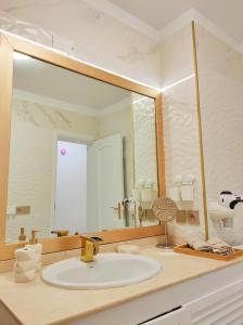 a bathroom with a sink and a large mirror at Golf del Sur Albatros Park Piscina Climatizada fast wifi in San Miguel de Abona