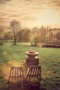 a picnic table and two benches in a field at Chalet de la Sablière in Amougies