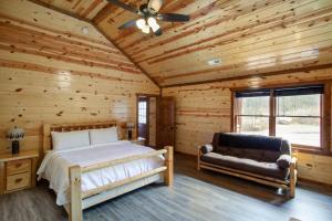 a bedroom with a bed and a couch in a log cabin at Pool and Game Room in Stunning Mountain Cabin in Pigeon Forge