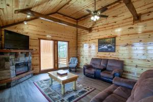 a living room with a couch and a fireplace in a log cabin at Pool and Game Room in Stunning Mountain Cabin in Pigeon Forge +49 photos