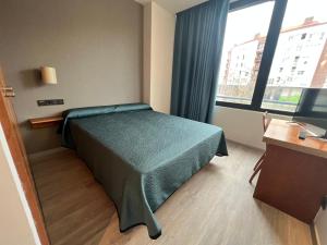 a bedroom with a bed and a large window at Duque de Wellington in Vitoria-Gasteiz