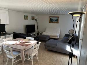 a living room with a table and a couch at Lille Øye Rest Aparment Nøtterøy in Nøtterøy