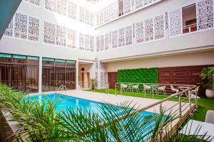 a villa with a swimming pool and a garden at Hôtel les Vallons in Abidjan