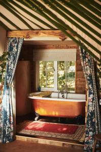 bañera en una habitación con ventana en Nature's Spectacular en Chew Stoke