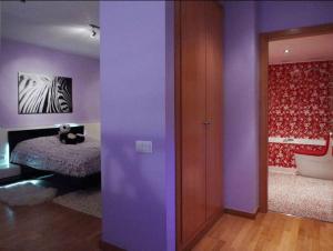 een kamer met paarse muren en een slaapkamer met een bed bij Vale Beach in Barcelona