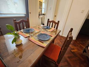 a dining room table with blue plates on it at Obelisco Apartment in Buenos Aires