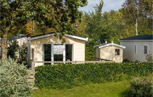 a small house in a yard with a fence at 2 Bedroom Gorgeous Home In Lauwersoog in Lauwersoog