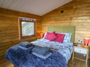 a bedroom with a bed in a log cabin at Tree House in Aberaeron