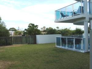 
a patio with a fence and a tennis court at Koola Beach Apartments Bargara in Bargara
