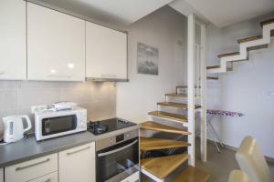 a kitchen with a microwave and a staircase at Holiday Home Aria in Podgora