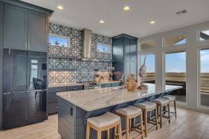 Una cocina con gabinetes azules y una gran isla con taburetes de bar. en BeachHouse Bliss, en Padre Island