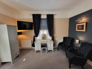 a living room with a couch and a table and a tv at Belle Vue Guest House in Denver