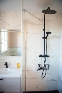 een douche in de badkamer met een wastafel en een douche bij NEW Remodeled Home 4Bed/3.5Bath, Walking to BEACH! in Saint-Lunaire