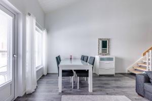 una sala da pranzo con tavolo e sedie bianchi di StarVillas B305 a Kalajoki