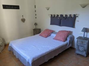Schlafzimmer mit einem Bett mit blauer Bettwäsche und roten Kissen in der Unterkunft Mas dans les lavandes in Ménerbes