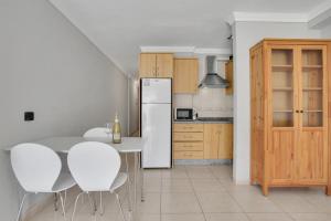 a kitchen with a white table and white chairs at Halcon - Costa del Silencio in Costa Del Silencio