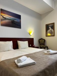 a hotel room with a bed with towels on it at Hotel CENTRAL Balchik in Balchik
