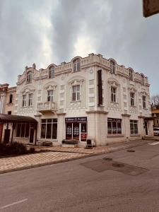 a large white building on the corner of a street at Hotel CENTRAL Balchik in Balchik