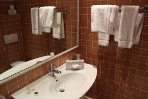 a bathroom with a sink and a mirror and towels at Hôtel Les Palmiers in Saint-Tropez +26 photos