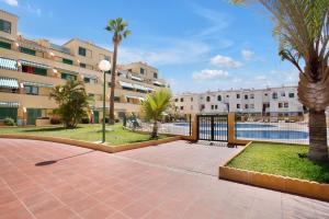 a courtyard with palm trees and a building at Halcon - Costa del Silencio in Costa Del Silencio