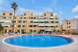 a hotel with a large swimming pool in front of a building at Halcon - Costa del Silencio in Costa Del Silencio