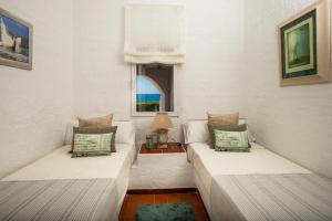 een woonkamer met 2 bedden en een tafel bij Villa Bini Sek in Binibeca