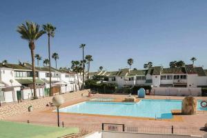 einen großen Pool mit Palmen und Häusern in der Unterkunft Suite Confort Free wifi in San Bartolomé de Tirajana