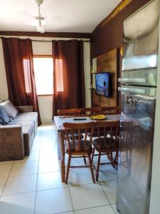 a kitchen and living room with a table and chairs at Casa Amarela in Maresias