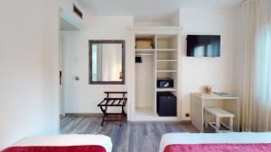 a bedroom with two beds and a mirror and a desk at Hotel Bella Dolores in Lloret de Mar