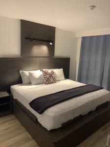 Schlafzimmer mit einem großen Bett mit einem Kopfteil aus Holz in der Unterkunft HOTEL PRINCESA PLAZA in Maracay