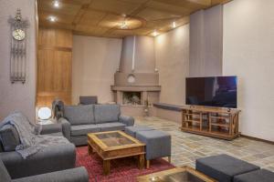 ein Wohnzimmer mit Sofas und einem Flachbild-TV in der Unterkunft Arahova Inn Hotel in Arachova