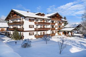 un gran edificio en la nieve con nieve en Hotel Rubihaus en Oberstdorf
