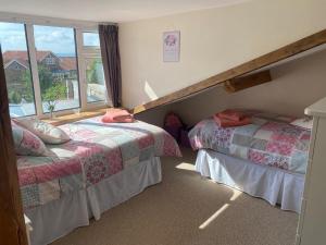 two beds in a room with a window at Seaview Cottage in Bridlington