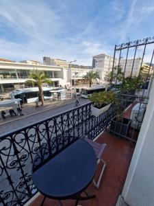 une table bleue et une chaise assise sur un balcon dans l'établissement Hôtel du Nord, à Cannes