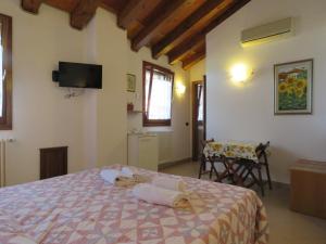 1 dormitorio con 1 cama, mesa y sillas en Agriturismo Ca' Marcello, en Mira