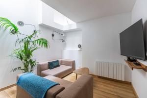 ein Wohnzimmer mit einem Sofa und einem TV in der Unterkunft Lavie Maison large comfy flat in Bordeaux