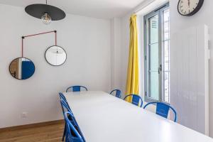 einen Tisch und Stühle in einem Zimmer mit einer Uhr in der Unterkunft Lavie Maison large comfy flat in Bordeaux