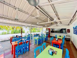 Condominio bahia blanca في كوفيناس: غرفة طعام مع طاولات وكراسي ملونة