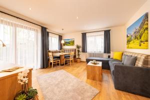 a living room with a couch and a table at Hotel Rubihaus in Oberstdorf