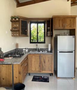 a kitchen with a white refrigerator and wooden cabinets at Villa Ladera de la Montańa in Jarabacoa