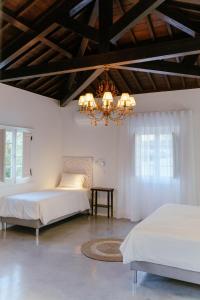 a bedroom with two beds and a chandelier at Senhora do Carmo Charm House in Ponta Delgada +53 photos