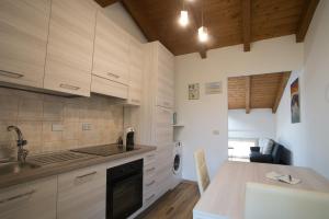 cocina con armarios de madera, fregadero y encimera en Il Borgo appartamento Luca en Parma